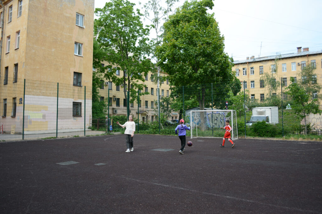 поле для мини-футбола, дети играют в мяч